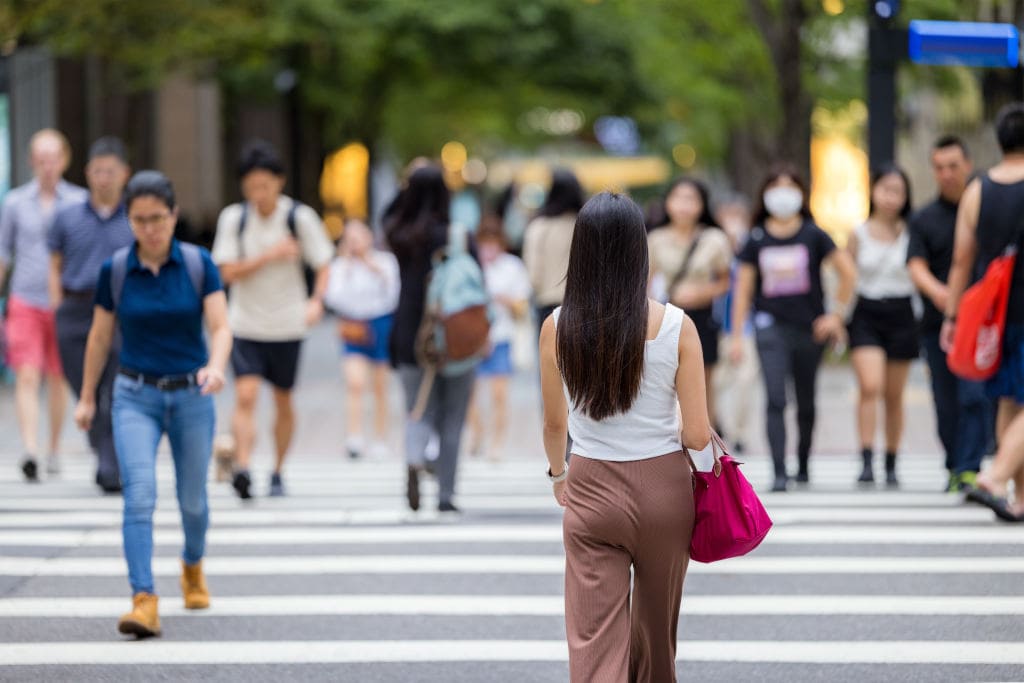 Busy Urban Crosswalk with Pedestrian Traffic Woman walking on crowded city crosswalk