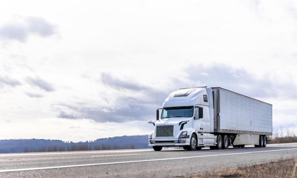 Truck on a Highway White Truck Driving Down on a Highway